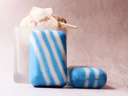 Blue and white soap bars with seashells on a light backgroundの写真素材