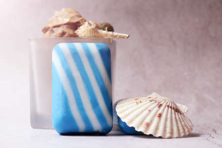 Blue and white striped soap with seashells on a light backgroundの写真素材