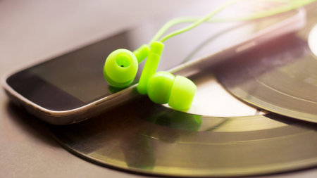Green vacuum headphones and a smartphone, a music device