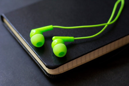 wired headphones and a paper leather notebook