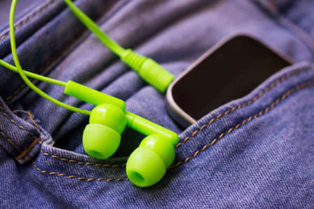 Green vacuum headphones and blue jeansの写真素材