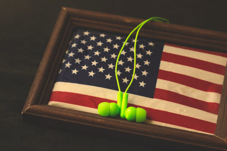 Green wired headphones and the US flag, English language training