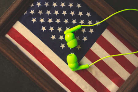 Green wired headphones and the US flag, English language trainingの写真素材