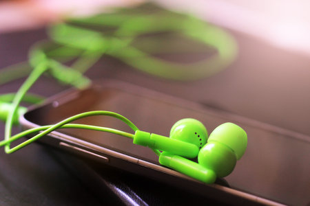 Green vacuum headphones and a smartphone, a music deviceの写真素材