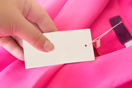 The price tag on a woman's pink jacket and women's fingers