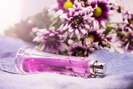 Women's perfume in glass on the background of a bouquet of chrysanthemums
