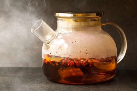 Hot rosehip drink in a glass teapot so closeの写真素材