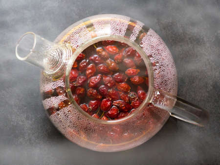 Hot rosehip drink in a glass teapotの写真素材