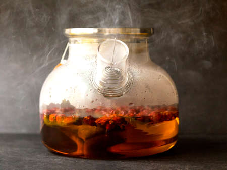 Hot rosehip drink in a glass teapotの写真素材