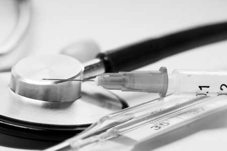 Stethoscope and syringe on the table. Black and whiteの写真素材