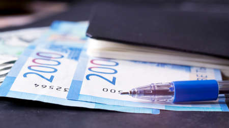 Euro banknotes and a pen on a black table close-upの写真素材