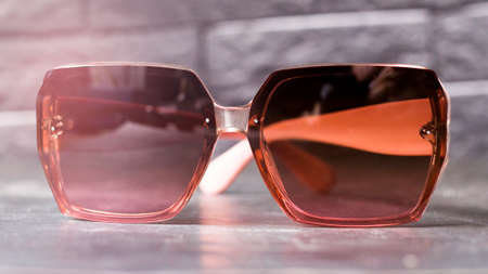 women's sunglasses with brown glasses on a gray background, close-upの写真素材