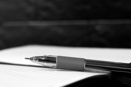 Pen and notebook on black background, closeup. Space for text