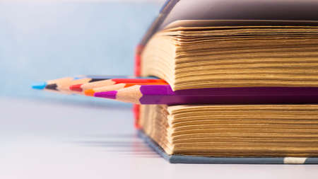 Close-up of a stack of books and pencils on a white backgroundの写真素材