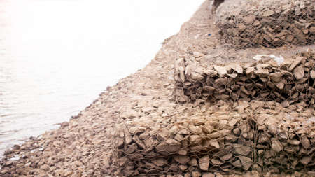 A low angle shot of stones on the seashore under the sunlightの写真素材