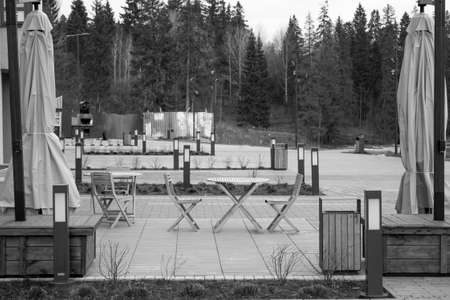 Wooden chairs and table in an outdoor area with umbrellas. Black and white photo.の写真素材