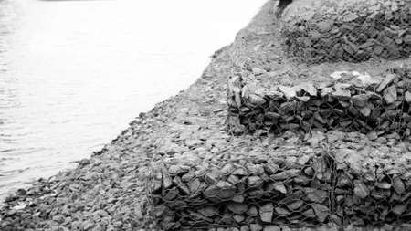 Black and white photo of stones on the bank of the river.の写真素材