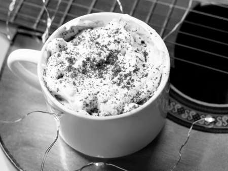 Cup of coffee with whipped cream on the table in black and whiteの写真素材