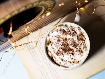 Cup of cappuccino with whipped cream and chocolate on a blue background.の写真素材