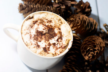 Cup of cappuccino with christmas decoration on wooden backgroundの写真素材