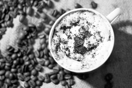 Coffee cup and coffee beans on sackcloth, black and white toneの写真素材