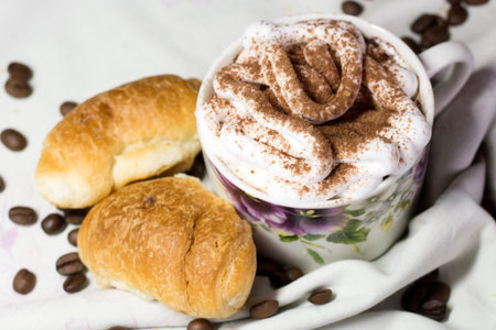 A cup of cappuccino and delicious croissants, delicious food
