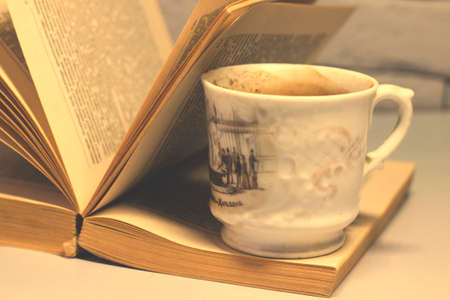 A cup of coffee and a book on the table. Selective focusの写真素材