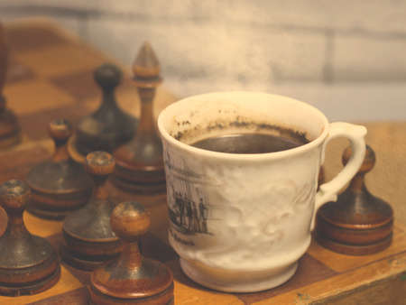 Cup of coffee and vintage wooden chess, retro photoの写真素材
