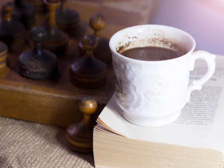 Cup of coffee and vintage wooden chess, retro photoの写真素材