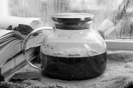 A black and white photo of a vintage jar on the windowsillの写真素材