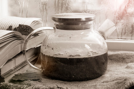 Tea in a glass teapot on the windowsill.の写真素材