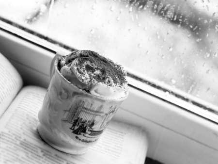 Cup of coffee with cake on the windowsill. Black and whiteの写真素材