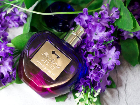November 27, 2021. Izhevsk, Russia. Perfume in a purple bottle and flowers.