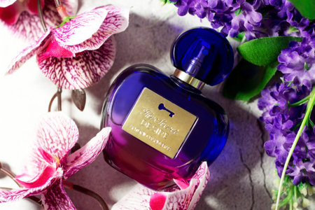 November 27, 2021. Izhevsk, Russia. Perfume in a purple bottle and flowers.