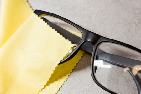 Black-rimmed eyeglasses and a yellow napkinの写真素材