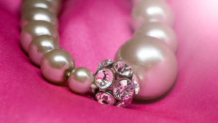 Bracelet made of beads and rhinestones on a pink backgroundの写真素材