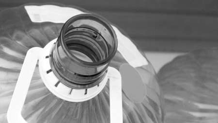 Plastic bottle of water on the table. Black and white photo.の写真素材