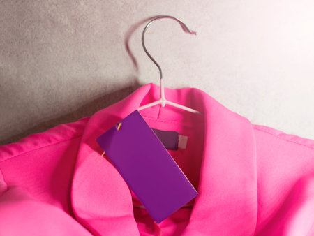 Lilac price tag and pink jacket on hangersの写真素材