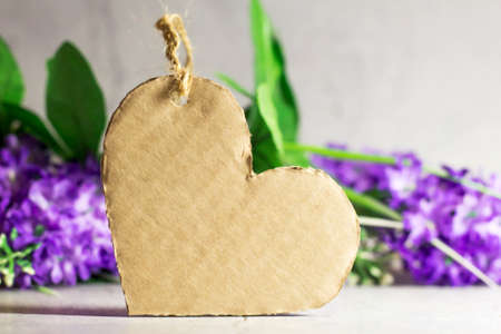 Cardboard heart on a background of flowersの写真素材