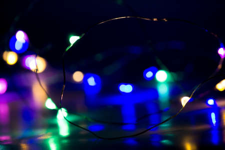 Christmas lights on a dark background. Colorful bokeh.の写真素材