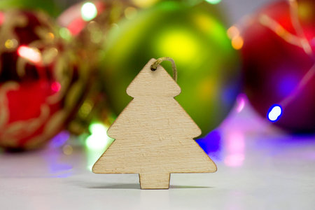 Wooden Christmas tree toy on the background of Christmas balls