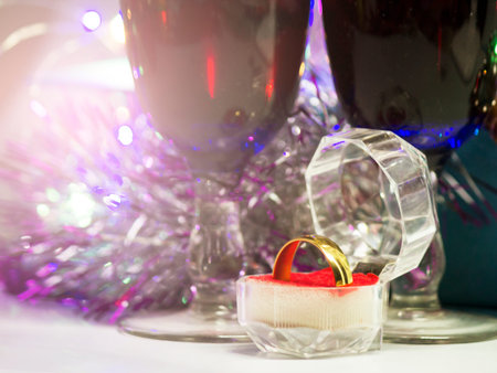 A golden ring in a glass box on the background of a Christmas decor