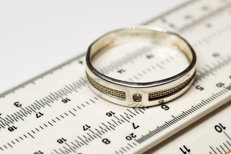 Wedding rings on a white background with a slide rule.の写真素材