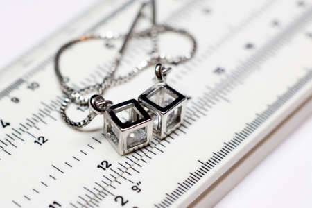 Silver earrings on a measuring device in a pawnshopの写真素材