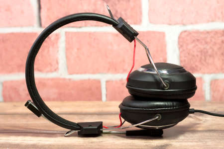 Black headphones on pink brick wall background very closeの写真素材