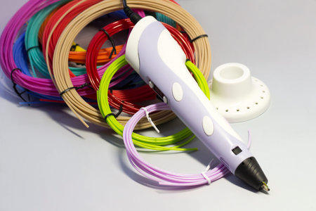 Purple 3d pen and rolls of colored plastic so close