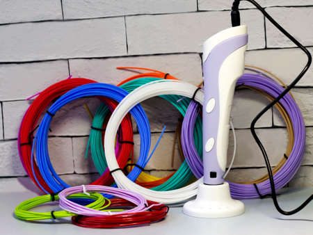 Purple 3d pen and rolls of colored plastic, creative tool, hobbyの写真素材