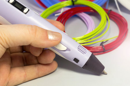 Purple 3d pen and rolls of colored plastic, creative tool