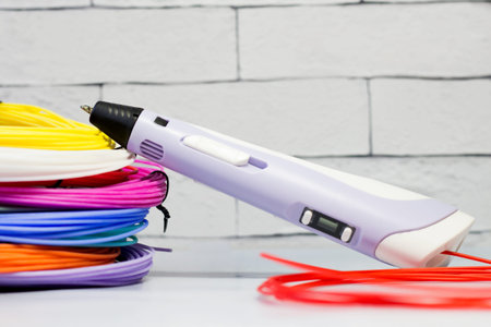 Purple 3d pen and rolls of colored plastic, creative tool