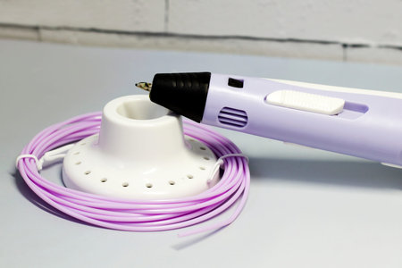 Purple 3d pen and rolls of colored plastic, creative tool